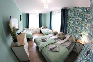 2 łóżka w pokoju z zielonymi ścianami w obiekcie Apartamenty Zielone Centrum w Stroniu Śląskim