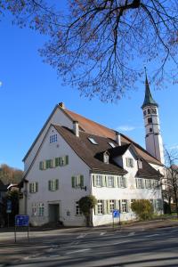 een groot wit gebouw met een klokkentoren bij Hotel Linde Leutkirch in Leutkirch im Allgäu