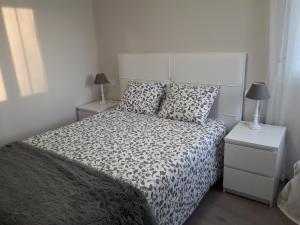 a bedroom with a black and white bed and two night stands at Céntrico y acogedor en tierra de vinos in Logroño