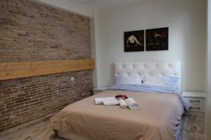 a bedroom with a brick wall and a bed with towels at George Studio in Athens
