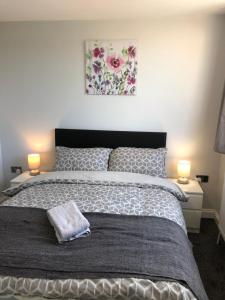 um quarto com uma cama grande e 2 candeeiros em Blueville House, Bluewater, 4 Bedroom Houses, Greenhithe, Dartford, Kent-Hosted by Castile Accommodations Ltd em Kent