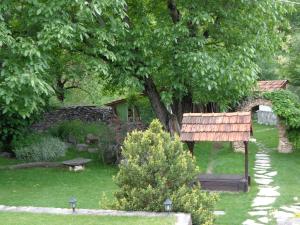 a garden with a wooden sign and a tree at ECO GARDEN in Dilijan