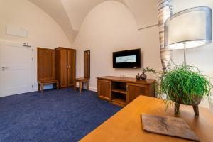 a living room with a desk and a tv at Hotel Panský Pivovar in Holešov