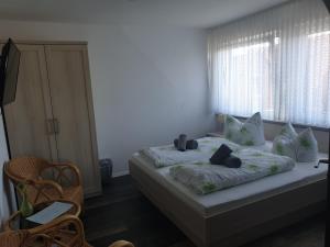 a bedroom with a bed with two pillows and a window at Hotel Nordseegruß in Norddeich