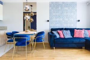 a living room with a blue couch and a table and chairs at Klif Residence in Władysławowo