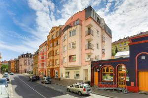 a building on a city street with cars parked on the street at Apartment Carla in Karlovy Vary