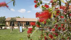 una casa con flores rojas delante de ella en Corte degli Angeli, en Marina di Grosseto