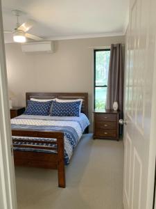 - une chambre avec un lit doté d'oreillers bleus et d'une fenêtre dans l'établissement Melawondi Spring Retreat, à Imbil