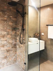 a bathroom with a glass shower with a sink at Rainforest Gardens - Luxury Hillside Accomodation with Views to Bay & Islands in Mount Cotton