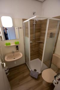 a bathroom with a shower and a sink at Hotel Norden Norddeich in Norddeich