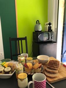 een tafel met brood en ander voedsel erop bij Le jardin de félicie in Trévoux
