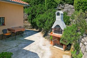 d'une terrasse avec un four en briques à côté d'une table. dans l'établissement Charming Opatija Getaway w Panoramic Sea Views and Rewarded Garden, à Opatija