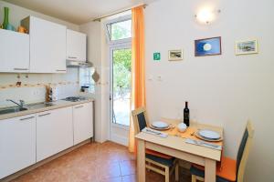 une petite cuisine avec une table et une table et des chaises dans l'établissement Charming Opatija Getaway w Panoramic Sea Views and Rewarded Garden, à Opatija