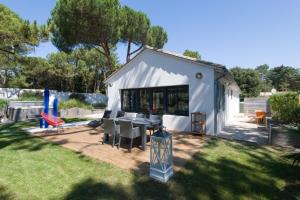 Tenda bianca con tavolo e sedie in cortile di Villa Ensoleillée a Sainte-Marie-de-Ré