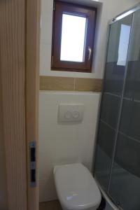 a small bathroom with a toilet and a window at OSADA CZTERY PORY ROKU - DOM WIOSNA in Kopalino