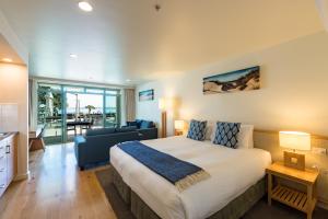 1 dormitorio con 1 cama y sala de estar en Paihia Beach Resort & Spa Hotel, en Paihia