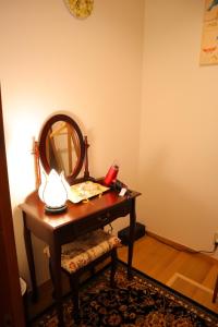 a dressing table with a mirror and a lamp on it at 熱海の海が一望できる温泉付貸別荘 満月あじろ mitsukiajiro in Atami