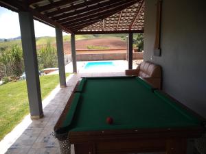 a pool table in front of a house at Chácara solar das águas II in Socorro
