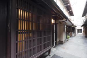 een gebouw met een hek aan de zijkant bij Kakishibu an Machiya House in Kyoto