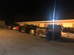 Una fila de autos estacionados en un estacionamiento por la noche en Rivers Inn, en Fort Madison