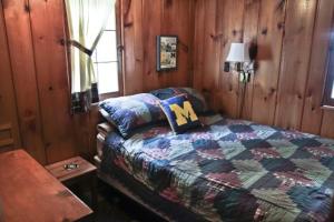 a bedroom with a bed in a room with wooden walls at Cabin #2 - M Den cabin in Carp Lake