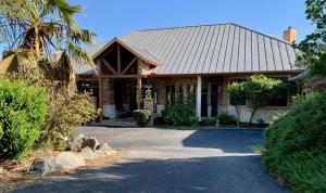 a house with a palm tree in front of it at Scenic Hill Country Retreat - Rhino Ranch in New Braunfels