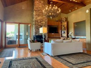 a living room with a white couch and a chandelier at Scenic Hill Country Retreat - Rhino Ranch in New Braunfels