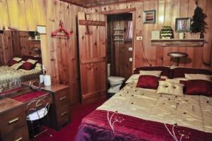 a bedroom with a bed and a desk and a toilet at Cabin #6 - Casablanca cabin in Carp Lake