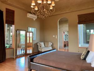 a bedroom with a large bed and a chandelier at Scenic Hill Country Retreat - Rhino Ranch in New Braunfels