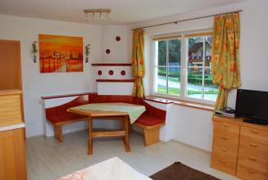 a living room with a table and a window at FeWo Burgstaller in Tröpolach