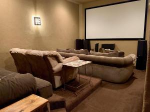 a living room with couches and a projection screen at Scenic Hill Country Retreat - Rhino Ranch in New Braunfels