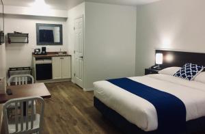 a hotel room with a bed and a kitchen at Humpback Inn in Port McNeill