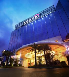 ein großes Gebäude mit Palmen davor in der Unterkunft Broadway Hotel in Macau