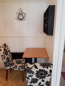 einen Tisch und einen Stuhl mit einer Tasse an der Wand in der Unterkunft Carvetii - Gemini House - 4 bed House sleeps up to 8 people in Tillicoultry