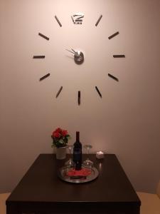 zegar na ścianie nad stołem z butelką wina w obiekcie Bed and Breakfast BLUE in BLUE w mieście Komiža