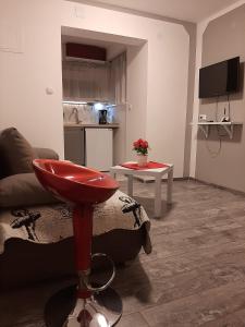 a living room with a red stool in front of a couch at Bed and Breakfast BLUE in BLUE in Komiža