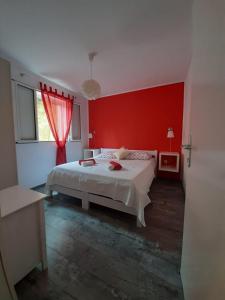 sypialnia z białym łóżkiem i czerwoną ścianą w obiekcie Bed and Breakfast BLUE in BLUE w mieście Komiža