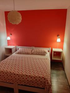 a bedroom with a bed with a red wall at Bed and Breakfast BLUE in BLUE in Komiža