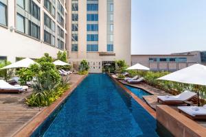 an infinity pool with lounge chairs and umbrellas at a hotel at Hyatt Ahmedabad in Ahmedabad