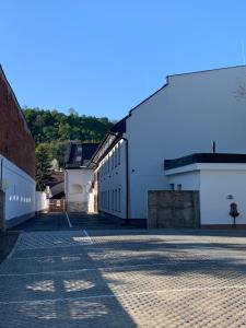 an empty street with white buildings and a blue sky at M70 Apartmanház in Miskolc