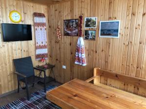 ゴルビツカヤにあるVacation Homes in Truzhenik Moryaの木製の壁の客室で、テーブル、テレビが備わります。