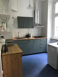 eine Küche mit blauen Schränken und einer Arbeitsplatte in der Unterkunft Klein App in Alt - Tegel in Berlin