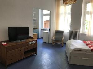 Dormitorio con cama y tocador con TV en Klein App in Alt - Tegel en Berlín