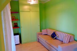 sala de estar con sofá y paredes verdes en Sea&Sky Apartment, en Víngla