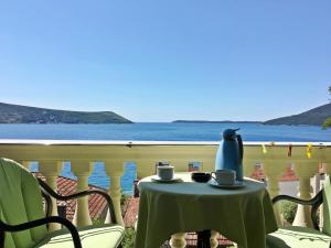 a table with two cups on it with a view of the water at Garni Hotel Bokeška Noć in Herceg-Novi