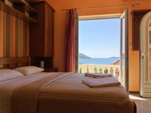 a bedroom with a bed with a view of the ocean at Garni Hotel Bokeška Noć in Herceg-Novi