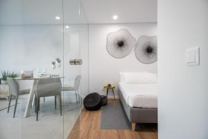 a bedroom with a bed and a dining room with a table at RM Loft in Setúbal