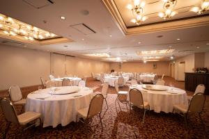a banquet hall with white tables and chairs at Hotel Green Park Suzuka in Suzuka