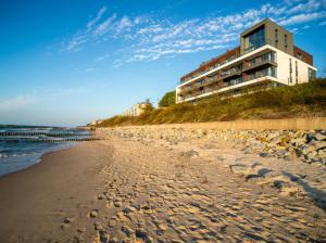 budynek na wzgórzu obok plaży w obiekcie Apartos Sailor - Luxury Apartments w mieście Ustronie Morskie