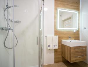 łazienka z prysznicem, umywalką i lustrem w obiekcie Apartos Sailor - Luxury Apartments w mieście Ustronie Morskie +37 zdjęć